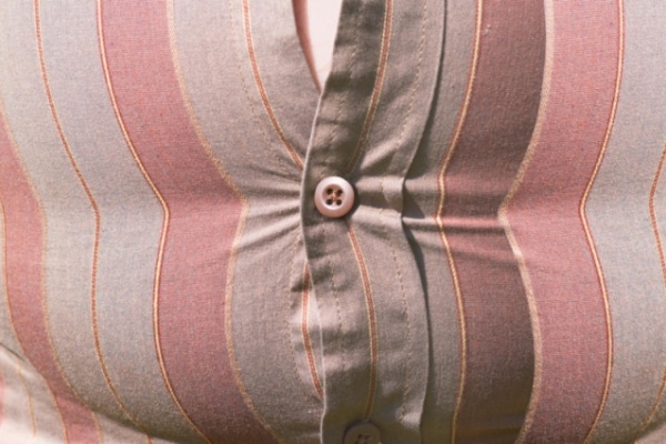 Kövér ember hasán feszülő csíkos ing.