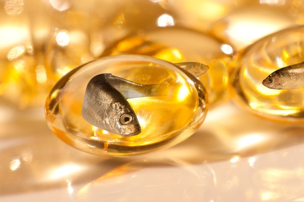 Omega-3 zsírsavat tartalmazó sárga gélkapszulák, melyekben halak úszkálnak, utalva ezzel a halolajra.