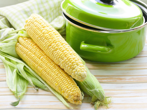 Zöld lábas, mellette főznivaló csemege kukoricák.