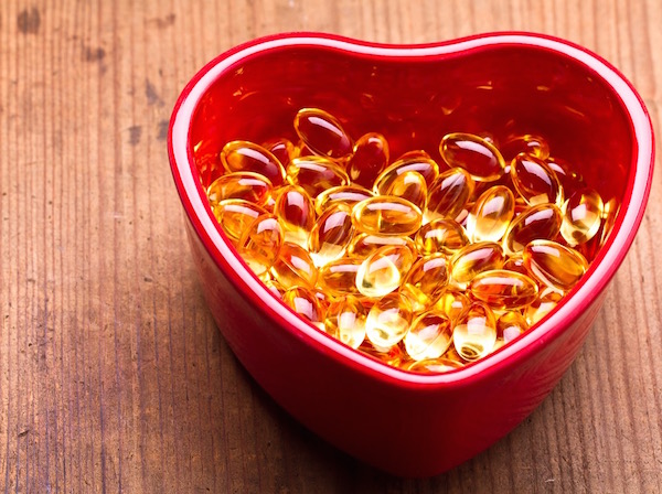 Egy szív alakú piros tál tele E-vitaminnal.