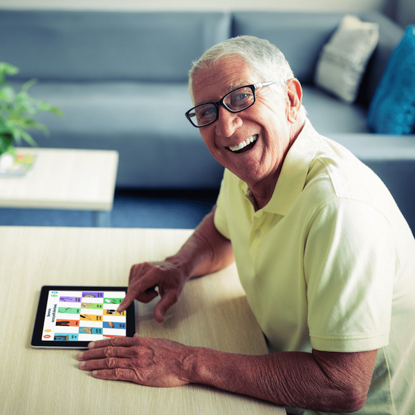 Kirakóst vagy memóriajátékot játszik az iPadjén egy idősebb férfi.