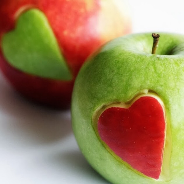Zöld és piros almából egy-egy szív kivágva, és az a másik almába beillesztve.
