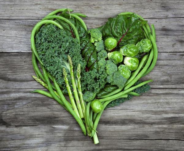 Zöld színű zöldségekből (kelkáposzta, brokkoli, kelbimbó, spárga, saláta, zöldbab) egy szív alak van megformázva.