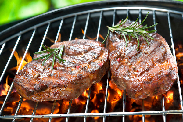 Faszénen grillezett steakszeletek friss rozmaringgal.