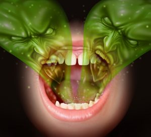 Emberi szájból kijövő két, zöld, fintorgó szörny - utalás a rossz leheletre.