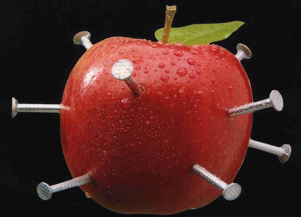 Piros almába szúrt vasszögek, melyek a népi hiedelem szerint tökéletesek vaspótlásra.