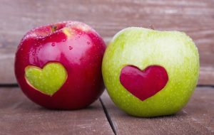 Egy piros és egy zöld színű alma, mindkettőn egy szív alakú bemetszés, melyet a másik alma színéből pótoltak.
