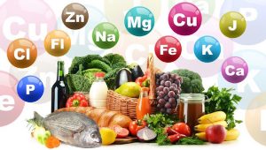 Különféle élelmiszerek, felettük színes körökben többféle nyomelem és ásványi anyag kémiai jelölése.