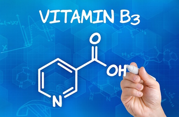 A B3-vitamin, azaz a niocin kémiai képletét írja fel valaki fehér filccel egy kék háttér elé.