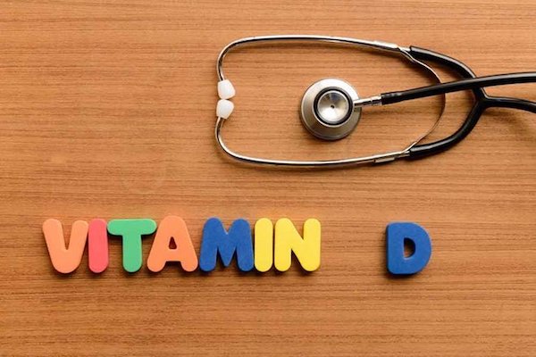 D-vitamin betűi kirakva színes mágnesekből, mellettük egy fonendoszkóp.