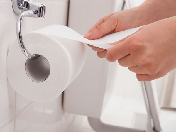 WC-papírt tép le egy hölgy a toalettben.