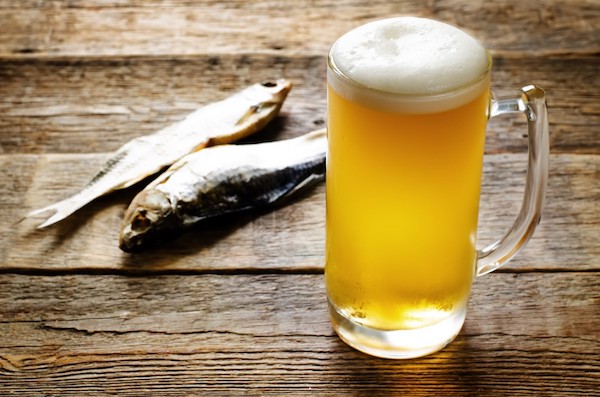Egy pohár sör az asztalon, mellette két hal.