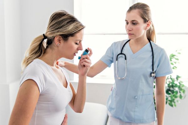 Egy orvosi rendelőben egy ápoló segít egy asztmás betegnek.