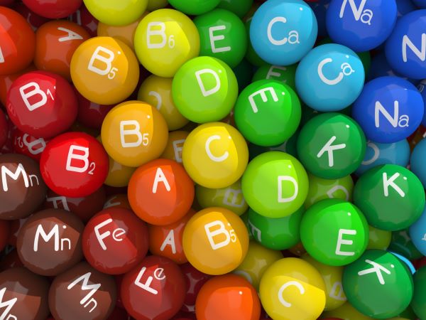 3D-s illusztráció: színes golyók vitaminok kezdőbetűivel, illetve ásványi anyagok vegyjelével.