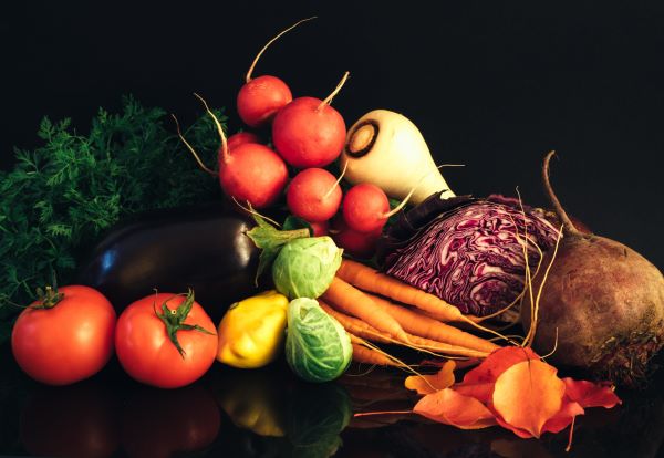 Zöldségek fekete háttérrel: padlizsán, cékla, retek, sárgarépa, kelbimbó, paradicsom, patisszon, lila káposzta.