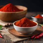 A kapszaicin fájdalmat csillapít és gyulladást csökkent Sötét faasztalon három különböző méretű tálban őrölt pirospaprika, mellettük chilipaprikák.