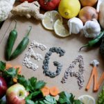 Körben zöldségek és gyümölcsök, középen zöldségekből és magvakból kirakva a "vegán" szó.