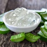 Faasztalon kis tálkában Aloe vera gél, körülötte Aloe vera levél darabjai.