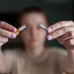 Nő kettétör egy cigarettát.