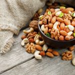 Barna tálban diófélék vegyesen: dió, mandula, pisztácia, kesudió, mogyoró.
