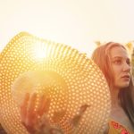 A napfény hiánya akár autoimmun betegséget is okozhat Fiatal nő kezében szalmakalappal sétál, amelyen átszűrődik a napfény.