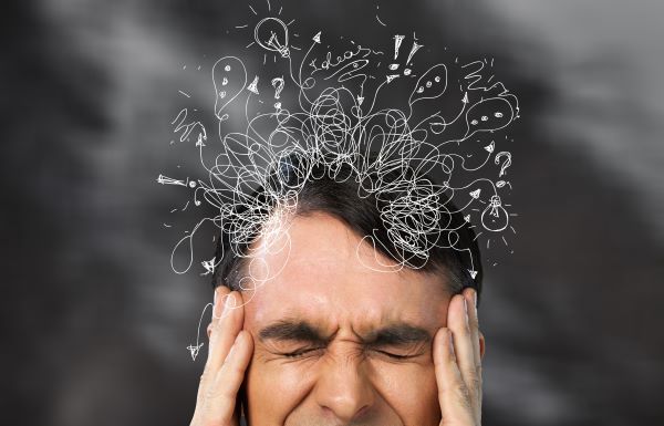 Stresszes férfi feje, felette rajzos illusztrációval.