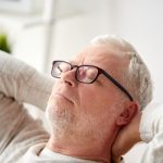 Az energiaszint növelhető – energianövelő tippek férfiaknak Középkorú szemüveges férfi kanapén pihen csukott szemmel.