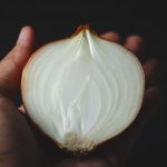 Mindennap egy hagyma a betegségeket is távol tartja – petrezselymes-citromos hagymasaláta-recepttel Közeli fotó tenyérben tartott fél hagymáról.