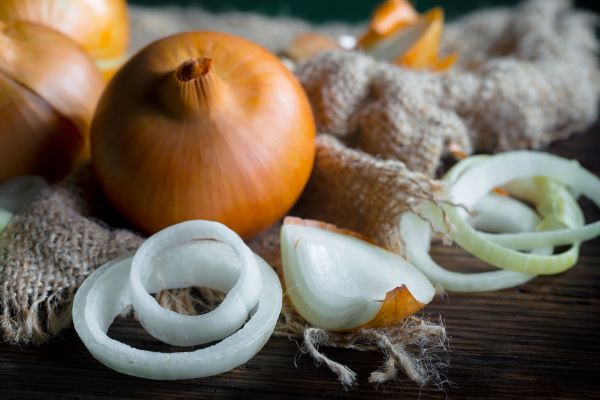 Közeli fotó néhány hagymáról és hagymaszeletek, -darabok.
