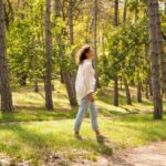 Fiatal nő sétál az erdőben.