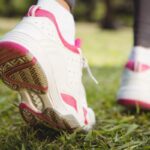 Nő sportcipőben gyalogol, a lábait látjuk közeli fotón, ahogy lép.