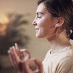 Nő csukott szemmel ülve meditál.