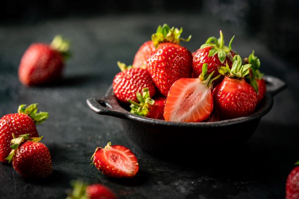 Fekete konyhapulton fekete tálban egy halom eper.