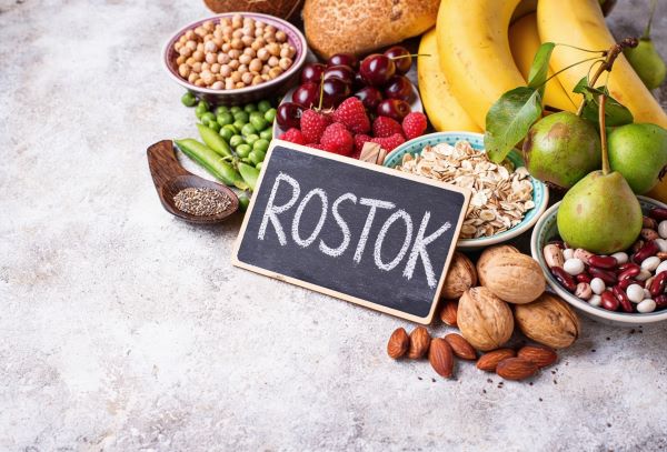Márványos felületen különböző élelmiszerek, előttük fekete táblán a "rostok" felirat.
