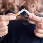 Nő kettétör egy cigarettát.